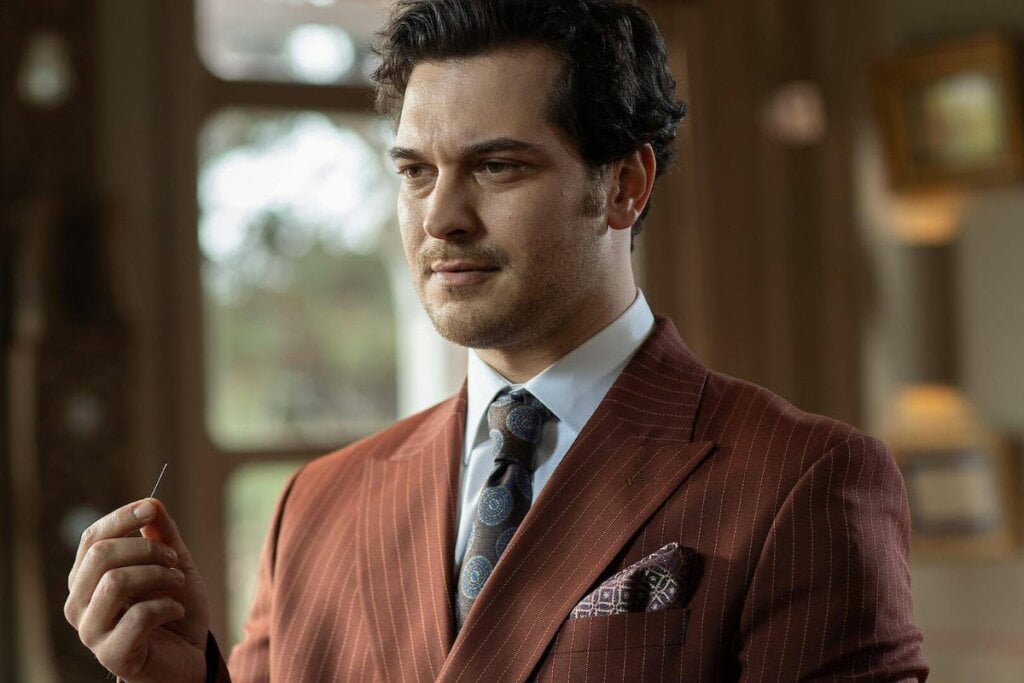 Ator Çağatay Ulusoy usando um terno marrom em cena da série "O Famoso Alfaiate"