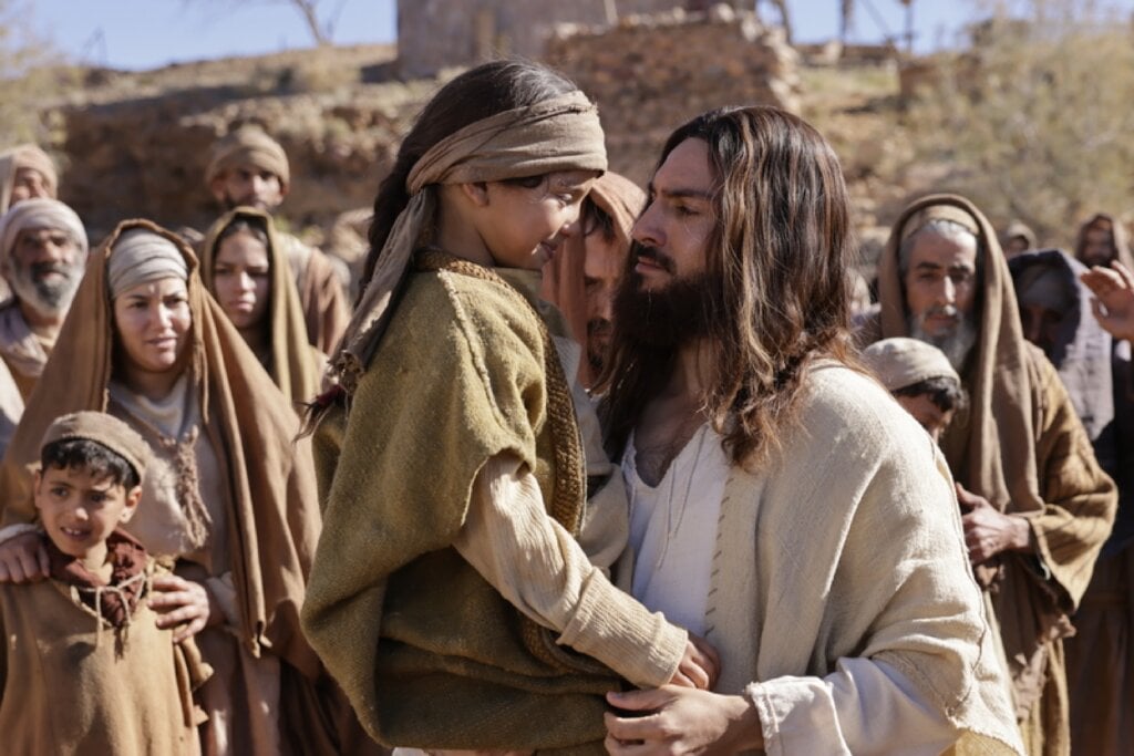 Jesus no filme"A última Ceia" segurando uma criança 