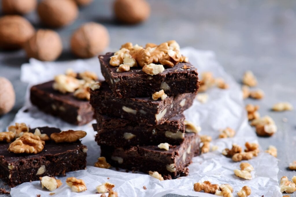 Pedaços de brownie empilhados e servidos em cima de mesa de pedra