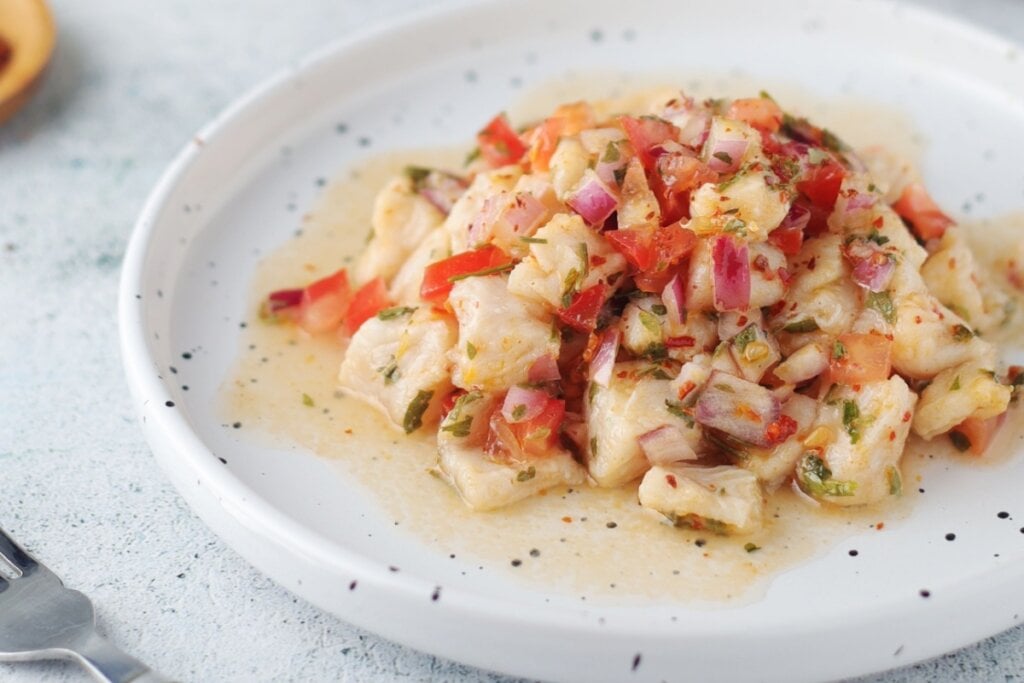 Prato branco com ceviche de robalo com tomate, cebola-roxa, salsinha e pimenta dedo-de-moça 