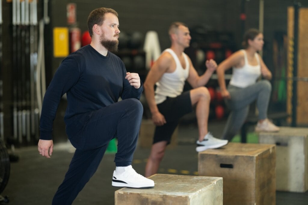 Três homens fazendo exercício de step-up