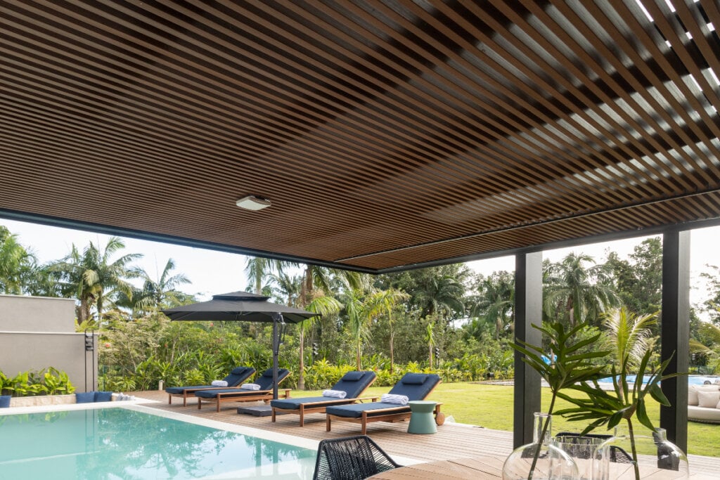 imagem de texto com ripado de madeira marrom e piscina ao fundo