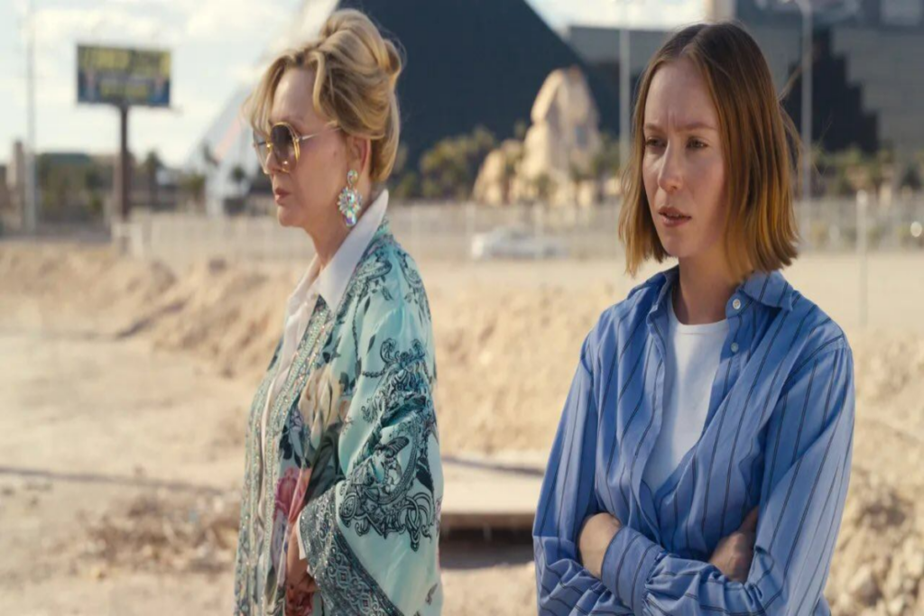 Duas mulheres vestidas com roupas em tom de azul, uma ruiva e outra loira no deserto