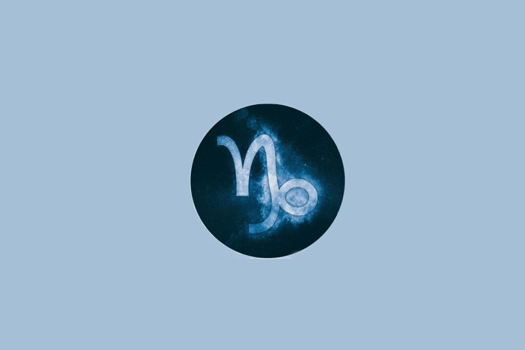 Ilustração do signo de Capricórnio, em fundo azulado, com símbolo que lembra uma combinação de N e espiral
