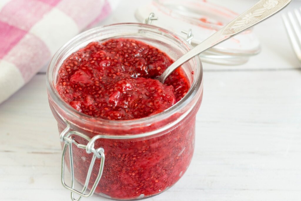 Recipiente de vidro com geleia vermelha e sementes de chia