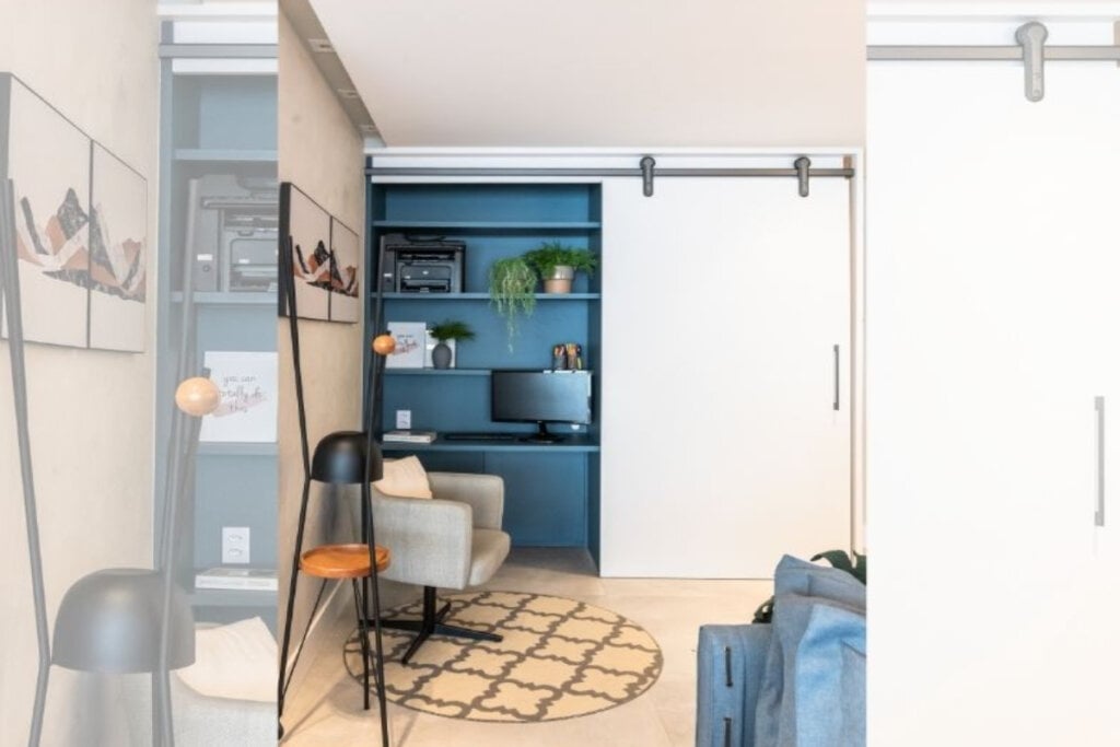 imagem  de homem office em tons de azul com cadeira cinza e porta de correr branca ao lado direito