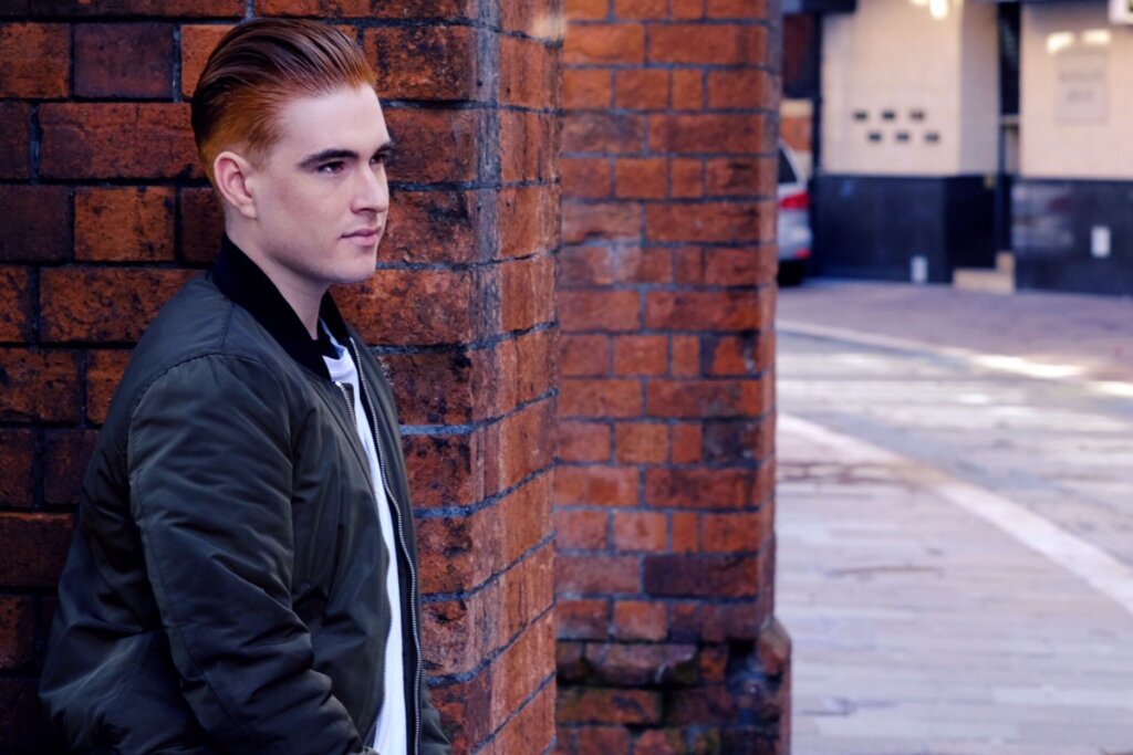 Homem ruivo com cabelo penteado para trás no estilo Slicked Back, com acabamento polido