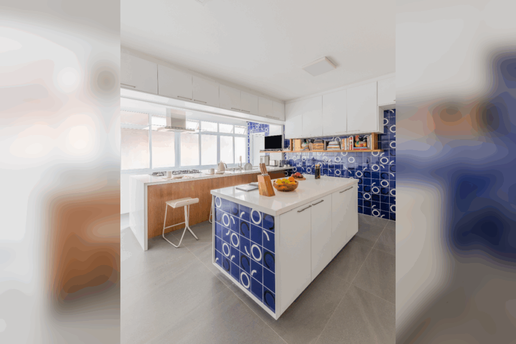 Cozinha moderna com ilha central revestida de azulejos azuis, bancada branca e ampla iluminação natural