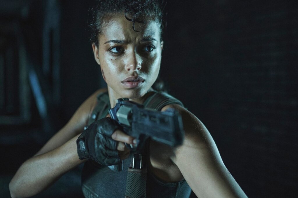 Cena de uma mulher segurando uma arma em "Resident Evil"
