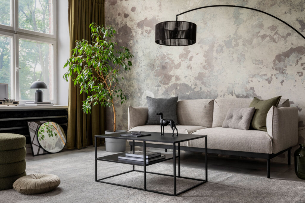 Sala de estar com decoração minimalista e industrial, sofá bege, mesa de centro preta e janela lateral