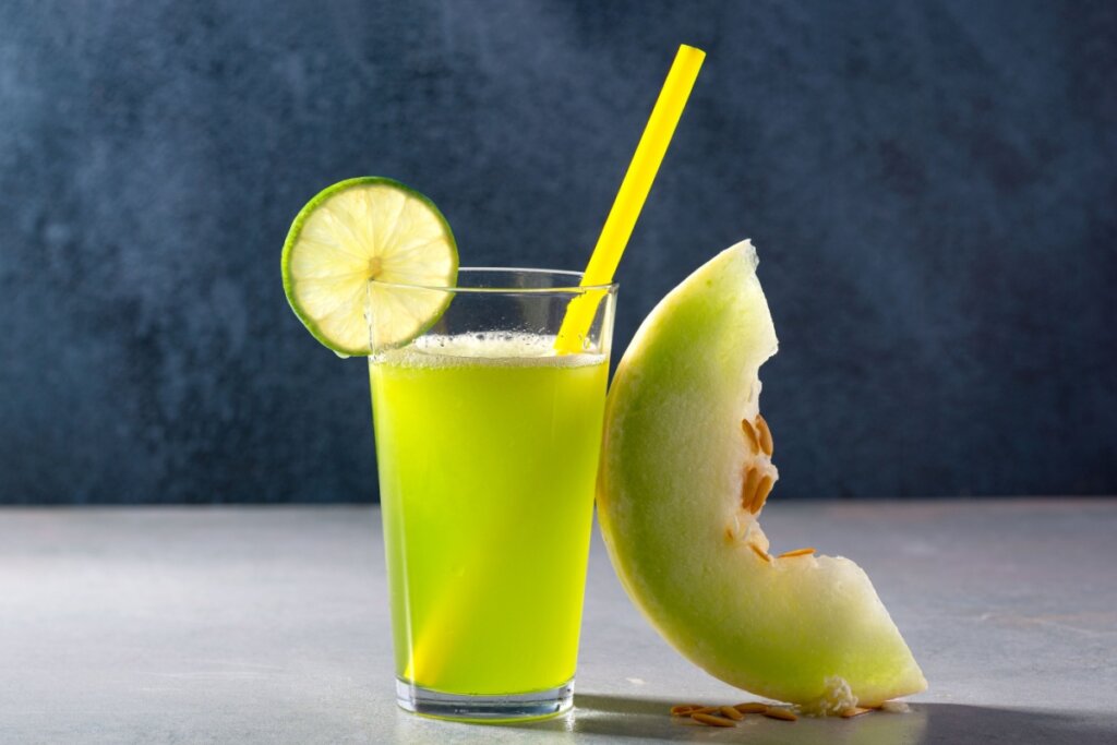 Suco de melão com limão e gengibre, servido em um copo de vidro, decorado com uma rodela de limão