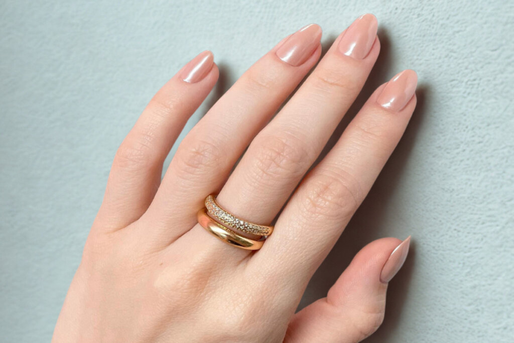 mão na parede com unhas em tom bege e perolado