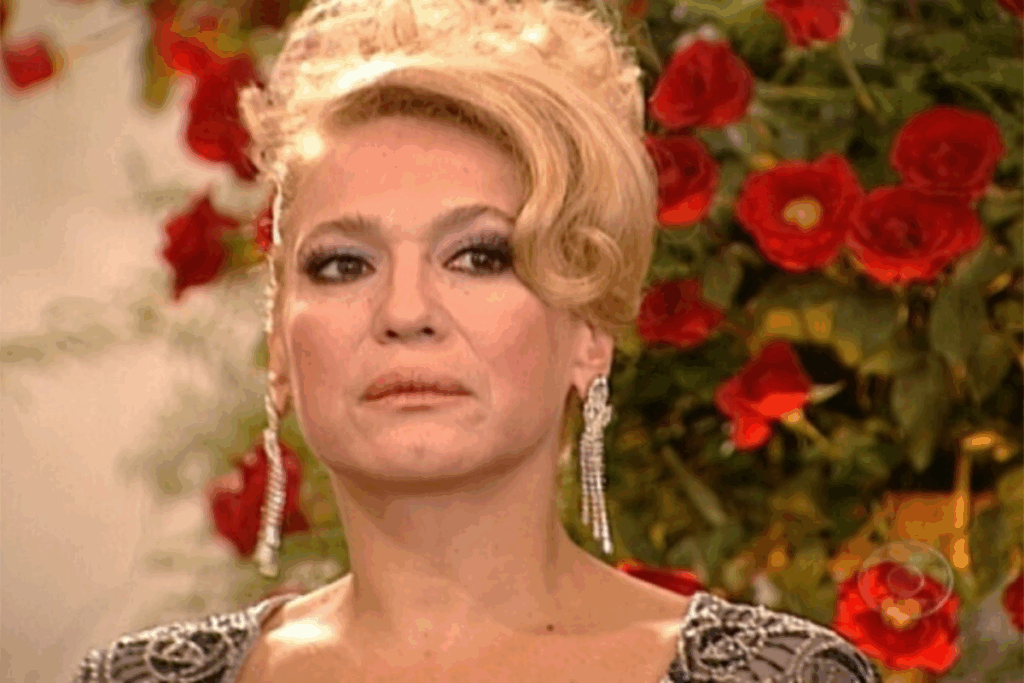 Close de mulher loira com penteado preso e maquiagem marcada, usando brincos longos