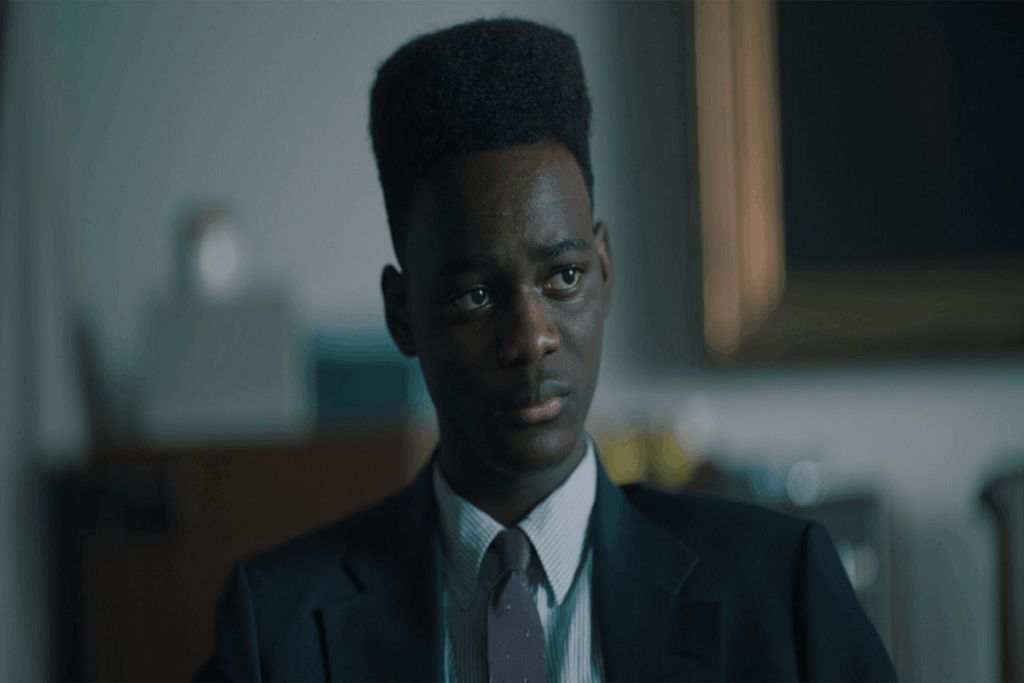 Imagem de um jovem negro com o cabelo curto e usando uniforme da escola com uma expressão preocupada