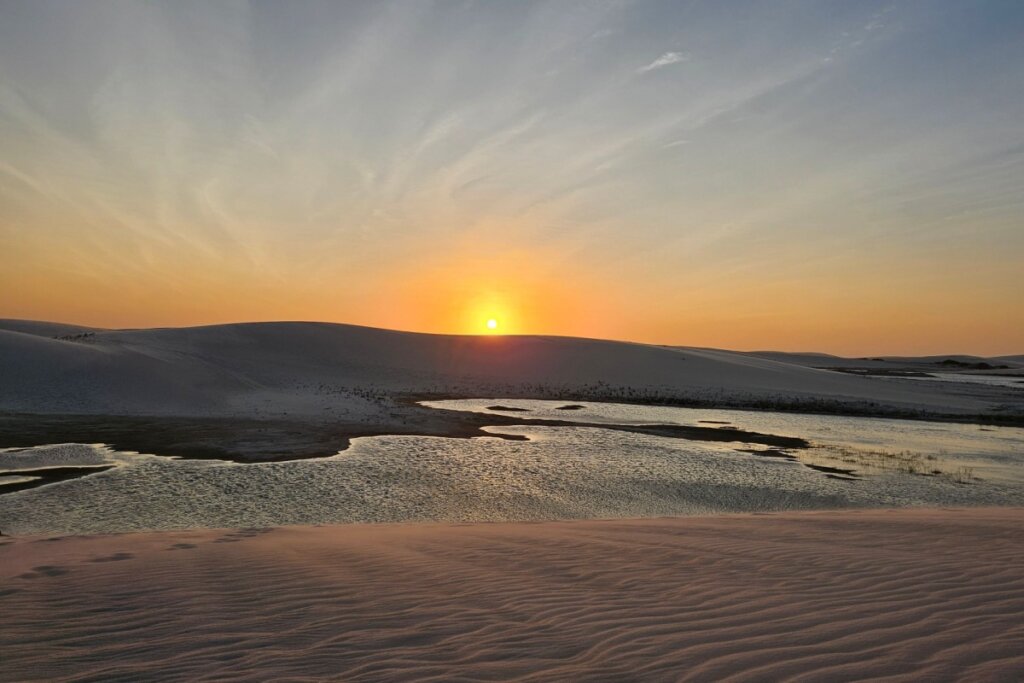 Pôr do sol nas dunas de Jericoacoara com águas abaixo das dunas 