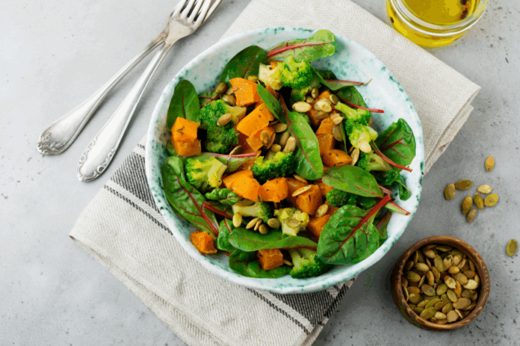 Salada morna de abóbora-moranga com folha de beterraba e brócolis em tigela branca e estampada
