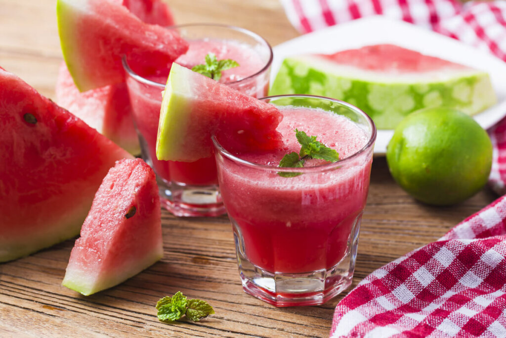 Suco de melancia em um copo transparente com folhas de hortelã decorando