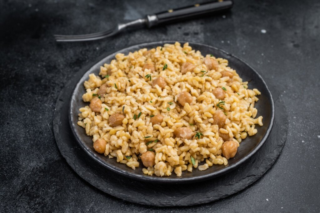 Arroz integral com grão-de-bico em um prato preto