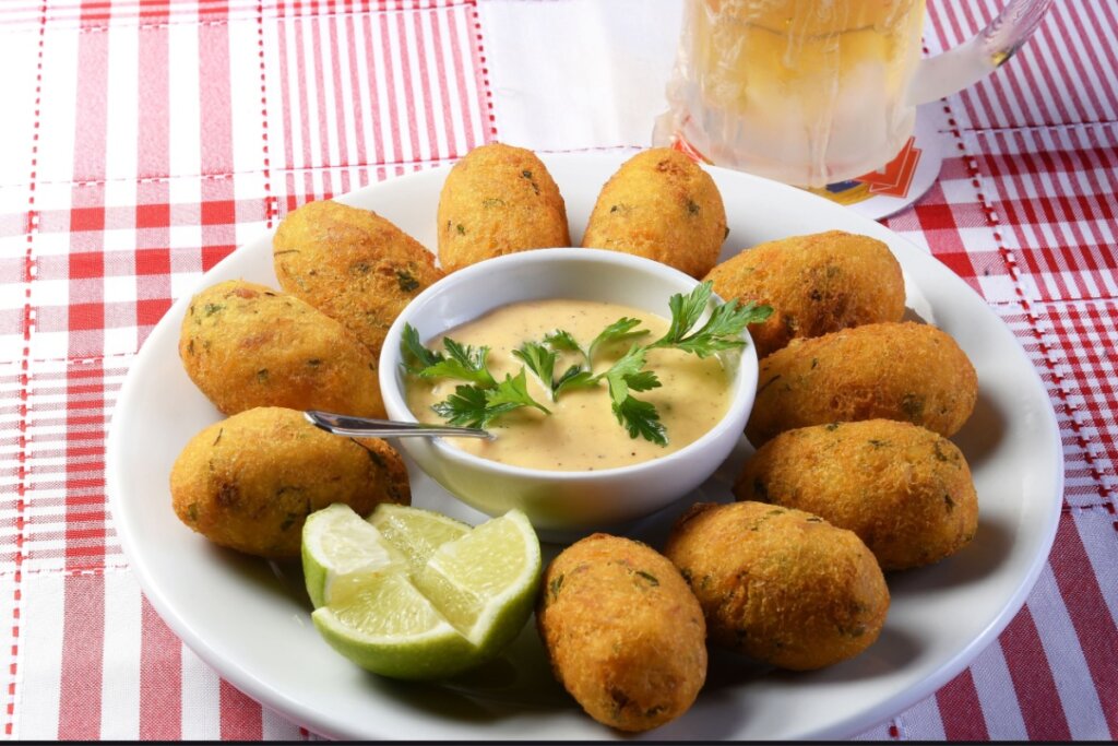 Bolinhos de bacalhau em um prato com fatias de limão 