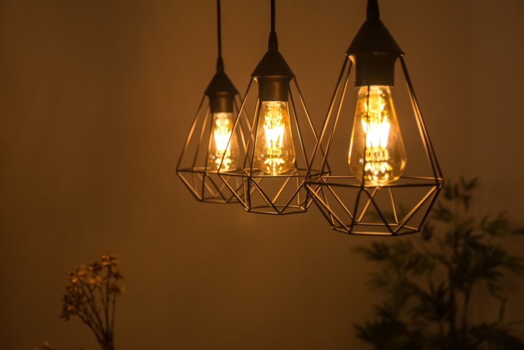 Três luminárias com lâmpadas amarelas