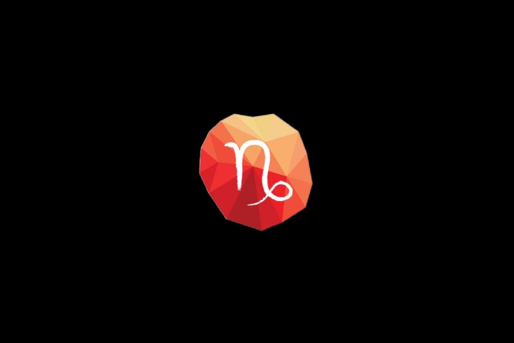 Ilustração do símbolo do signo de capricórnio em um cristal vermelho e laranja sobre o fundo preto