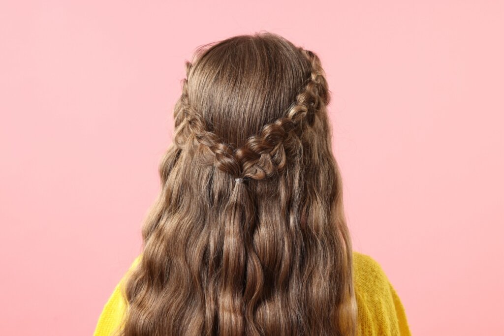 Mulher virada de costas e com cabelo semi-preso com trança