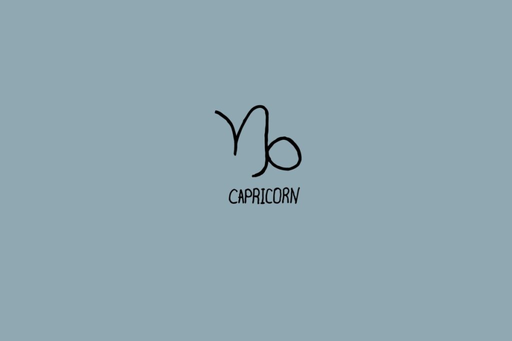 Ilustração do signo de capricórnio em preto em um fundo cinza com o nome do signo embaixo