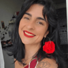 Mulher de cabelos escuros e brinco de argola com rosa vermelha