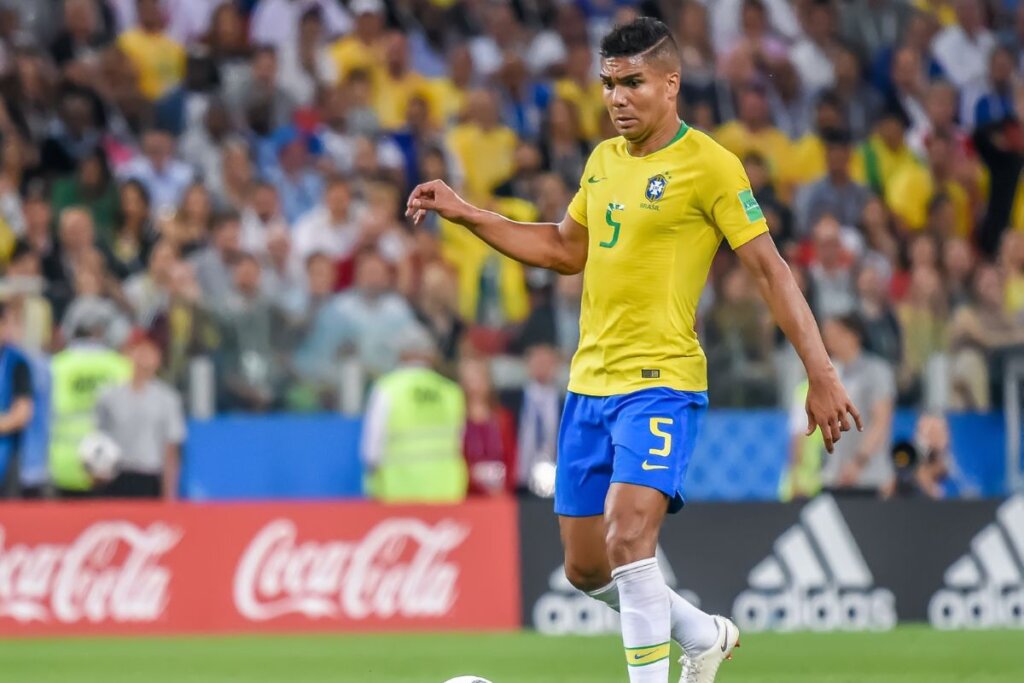 Casemiro jogando bola em campo usando a camisa da seleção brasileira