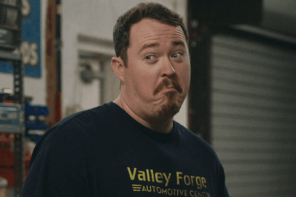 Homem de camiseta preta com a inscrição "Valley Forge" fazendo uma careta cômica e duvidosa.