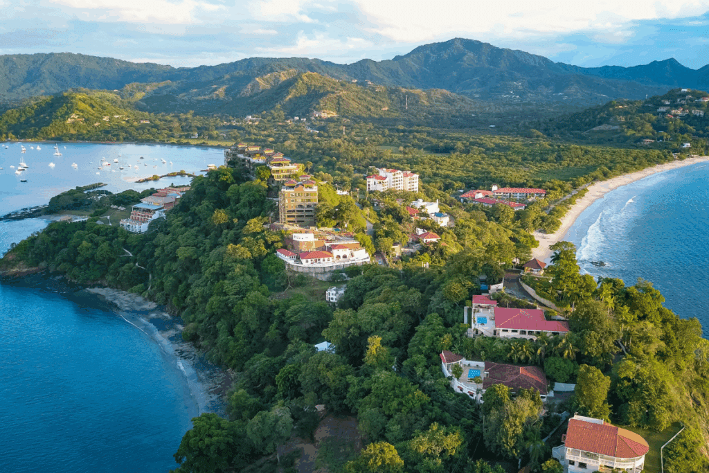 Imagem de cima de parte da Costa Rica mostrando montanhas, casas e as áreas de praia
