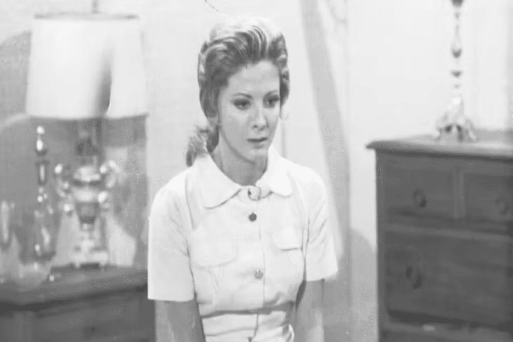 Imagem em preto de branco de mulher com cabelo preso usando camiseta polo branca