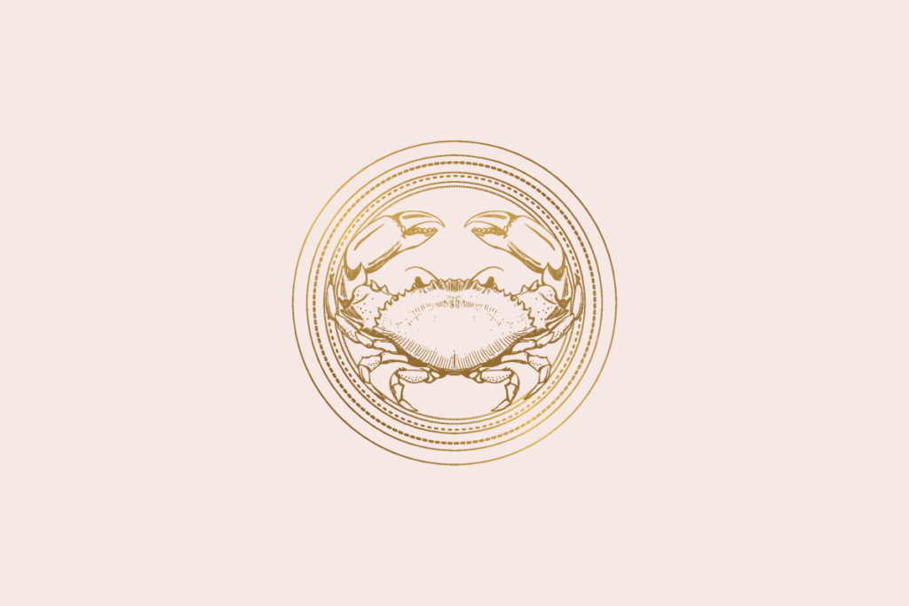 Ilustração do signo Câncer: gravura dourada de um caranguejo visto de cima, com as garras erguidas e as patas abertas, dentro de um medalhão de anéis dourados finos e pontilhados; em fundo rosa-claro.