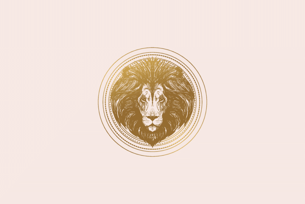Ilustração do signo Leão: gravura dourada da cabeça de um leão vista de frente, com uma juba volumosa que preenche quase todo o medalhão de anéis dourados finos e pontilhados; em fundo rosa-claro.