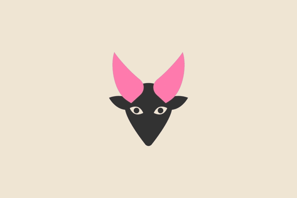 Ilustração do signo Capricórnio, contendo a cabeça de uma cabra preta vista de frente com chifres pontudos rosa, em fundo bege.