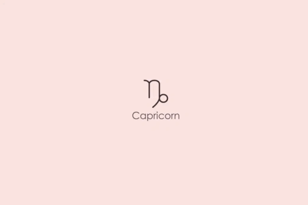 Ilustração minimalista do símbolo astrológico do signo de Capricórnio, formado por linhas finas e curvas em tom escuro. Abaixo, aparece a palavra “Capricorn”, em inglês. O fundo é rosa-claro.
